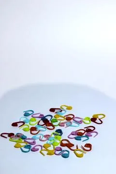 Plastic multi-colored knitting pins. colorful pins on the white background Stock Photos