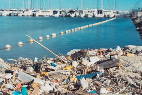 Plastic objects  washed up on the shore and yachts on the background.Marine p Foto stock