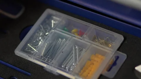 Plastic organizer box filled with various screws, dowels, and pins. Stock Footage 343890548