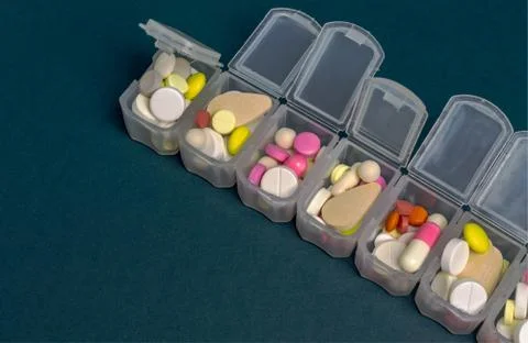 Plastic organizer for tablets. tablets are red, white, round. close-up Stock Photos