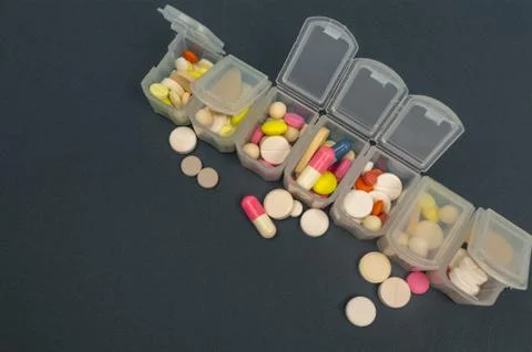 Plastic organizer for tablets. tablets are red, white, round. close-up Stock Photos