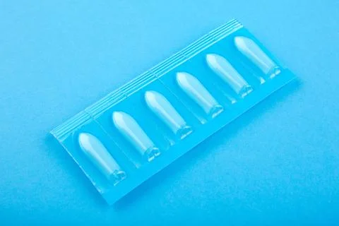 Plastic package with suppository on blue background Stock Photos