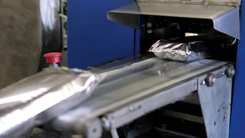 The plastic packaging machine on the production line packs food products Stock Footage 171894315