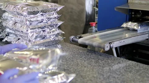 The plastic packaging machine on the production line packs food products Video stock 171894444