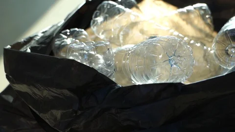 Plastic PET bottle in trash bag, handheld zoom-in slow motion Stock Footage 123959791