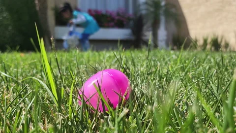 Plastic pink easter egg placed in the frontyard lawn Stock Footage 194620605