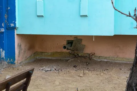 A plastic pipe for draining rainwater installed at the base of the house. San Stock Photos