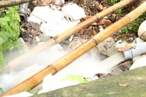 A plastic pipe that emits a very large discharge of fresh water. Stock Photos