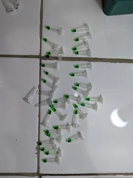 Plastic pipette tips arranged on white tiled floor Stock Photos