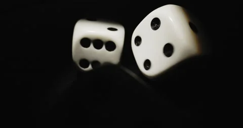 Plastic playing gambling dice rolling forever against dark background Vidéo 165340387