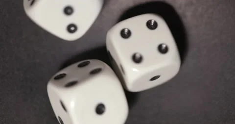 Plastic playing gambling dice rolling forever against dark background Vidéo 165340494