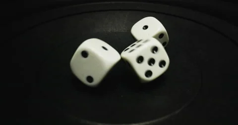 Plastic playing gambling dice rolling forever against dark background Vidéo 166245328