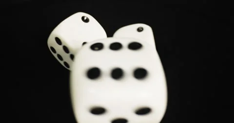 Plastic playing gambling dice rolling forever against dark background Vidéo 166383044