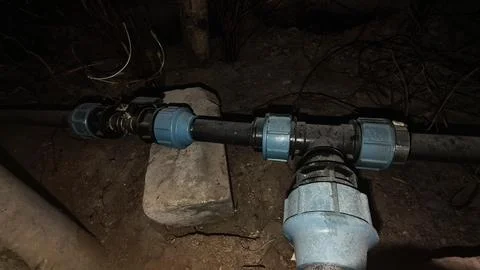 Plastic plumbing pipes fixed with compression fittings connecting a water supply Stockfoto's