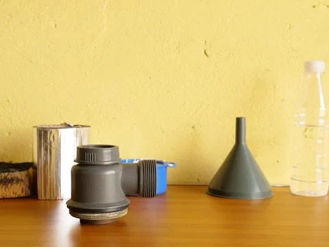 Plastic plumbing siphon with threaded outlet placed on wooden table against y Stock Photos
