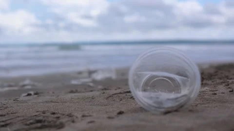 Plastic pollution on beach. Close-up of plastic garbage lays on sand, it will Stock Footage 257752061