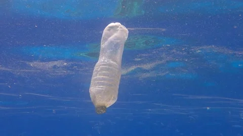 Plastic pollution, close up of the plastic bottle swim in blue water. Stock Footage 156299426