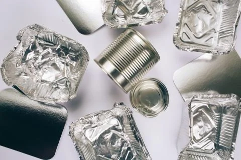 Plastic pollution concept. Foil silver container for food, silver cardboards and Stock Photos