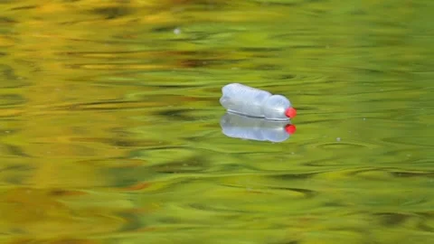 Plastic Pollution Floating Down a summer River in Slow Motion Stock Footage 340605260
