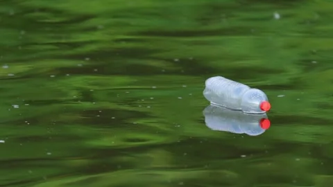 Plastic Pollution Floating Down a summer River in Slow Motion Stock Footage 340605262