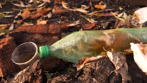 Plastic pollution of nature. Plastic bottle and glass on the grass. Stock Footage 126000545