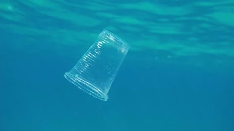 Plastic pollution in ocean, environmental problem. plastic cup in blue water Stock Footage 172342287