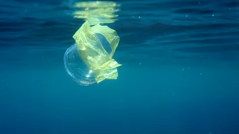 Plastic Pollution In Ocean. Plastic cocktail cup floating in tropical sea Видео 195495779