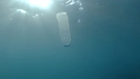 Plastic pollution, plastic bottle in blue water. Discarded plastic bottle Stock Footage 114766829