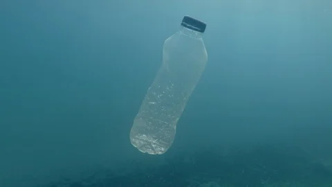 Plastic pollution, plastic bottle in blue water. Discarded plastic bottle Stock Footage 115418197