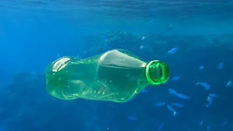 Plastic pollution, plastic bottle in blue water. Discarded green plastic bottle Stock Footage 142932622
