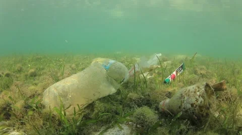Plastic pollution problem. Bottles and bags dumped in sea causing environmental  스톡 동영상 65450589