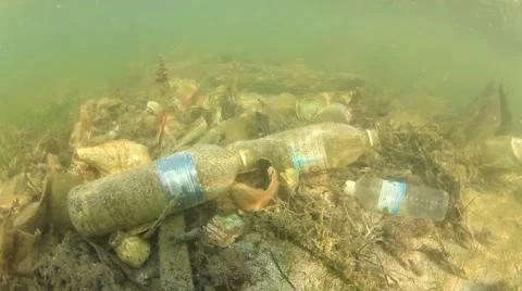 Plastic pollution problem. Bottles and bags dumped in sea causing environmental  스톡 동영상 65450601