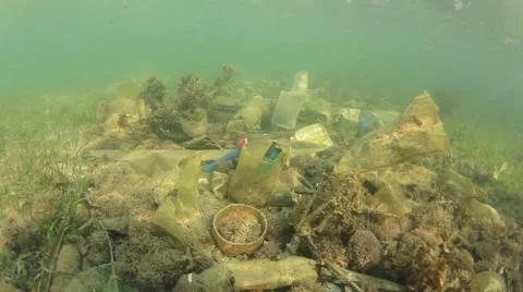 Plastic pollution problem. Bottles and bags dumped in sea causing environmental  스톡 동영상 65450610