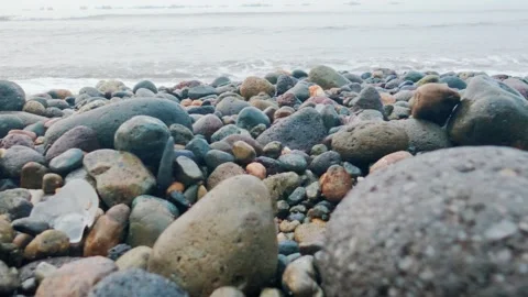 Plastic Pollution on Rocky Pebble Beach with Ocean Waves Stock Footage 337776528