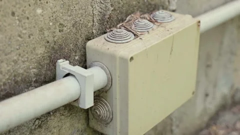 Plastic power supply box with two cables installed on the outer house wall, high Stock Footage 259957355