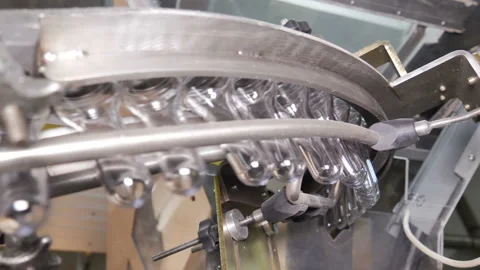 Plastic preform bottles move through the machine for blowing Stock Footage 98720014