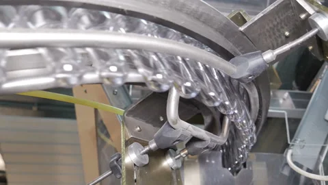 Plastic preform bottles move through the machine for blowing Stock Footage 98720415