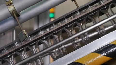 Plastic preform bottles move through the machine for blowing Stock Footage 98721431
