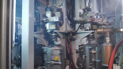 Plastic preform bottles move through the machine for blowing Stock Footage 98722289