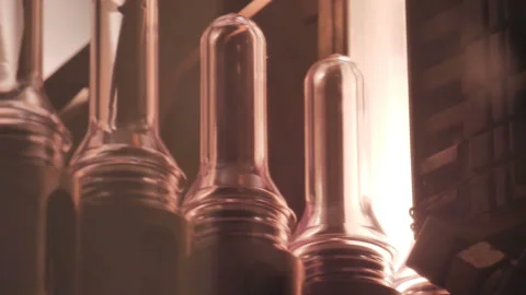 Plastic preform bottles move through the machine for blowing Stock Footage 98723759