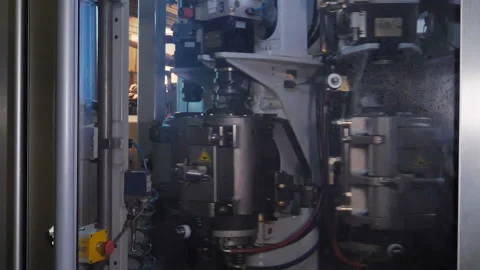 Plastic preform bottles move through the machine for blowing Stock Footage 98725493