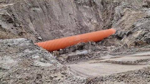 Plastic protective corrugation for cables or drainage laid in sandy soil Stock Footage 333110255