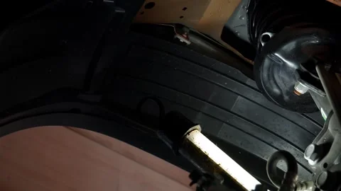 Plastic protective inserts of the wheel arch, bottom view, illuminated by a lamp Vídeos de archivo 248167037