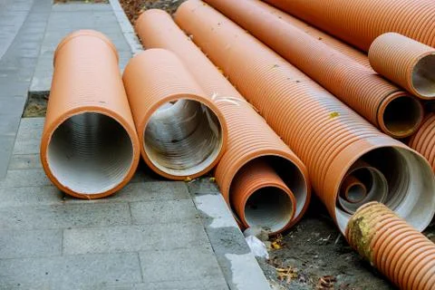 Plastic PVC pipes stacked in rows at a construction site on reconstruction of Stock Photos