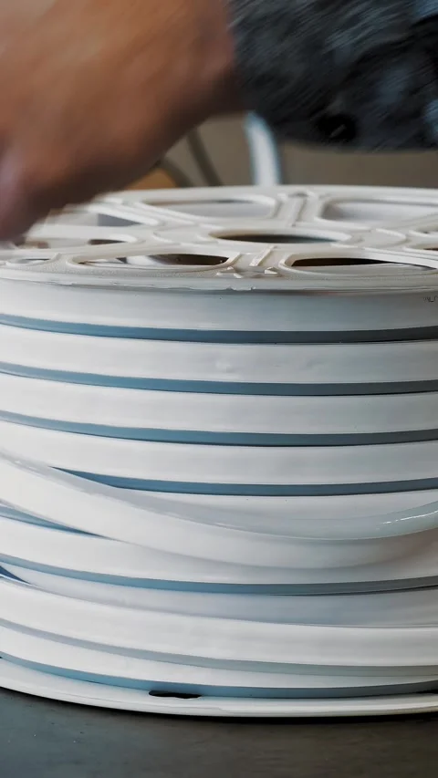 Plastic reel with LED strip. close-up. man winds LED neon lights tape on plastic Video stock 318683145