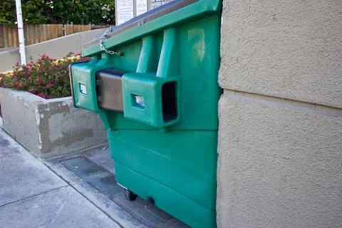 Plastic refuse container next to sidewalk Stock Photos