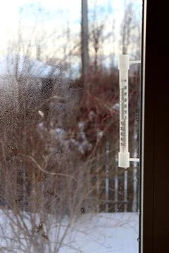 A plastic retro thermometer outside the window of a village house Stock Photos