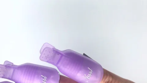 Plastic reusable cap clip for soak-off UV gel polish removal. Video stock 117675194