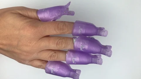 Plastic reusable cap clip for soak-off UV gel polish removal. Stock Footage 117822115