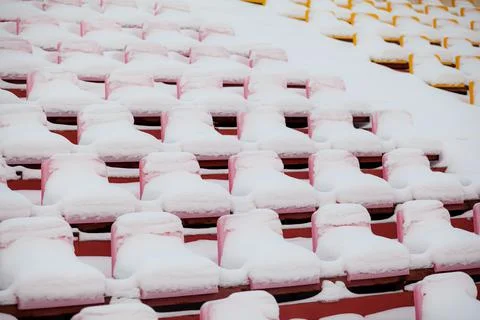 Plastic seats in a row at the stadium are covered with snow snow. Foto stock